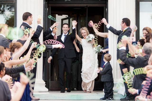 Clare and Brandon are greeted by colorful slinkies as they leave the Toledo Art Museum after their wedding ceremony.