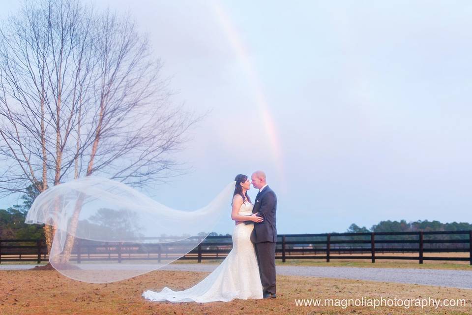 Couple poses under rainbow