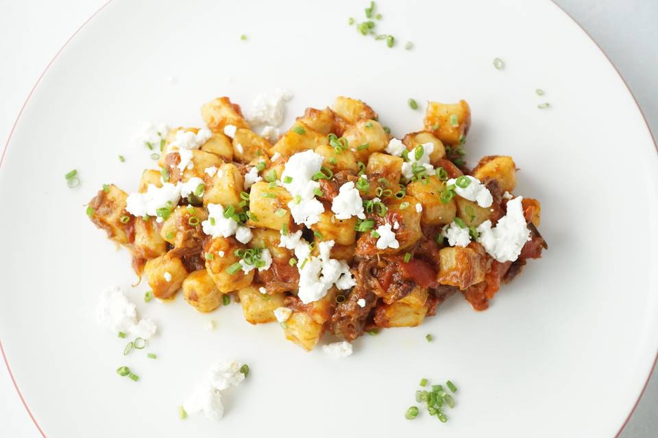 Gnocci with a red wine ragu, garnished with goat cheese