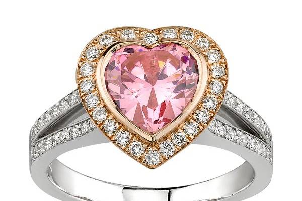 Beautiful Gold and Platinum Engagement Ring with Heart Shaped Pink Diamond with a Gold Halo set with Round Diamonds. Also features a split shank design with channel set Round Diamonds.