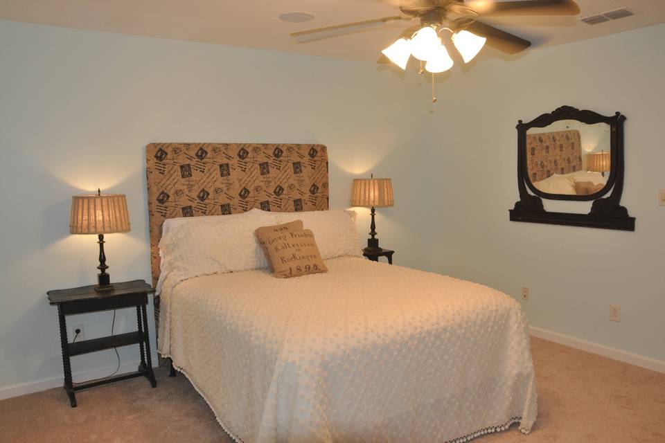 Upstairs bedroom with a queen size bed and shared bathroom.
