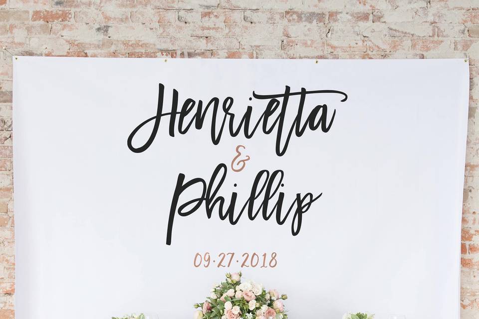 Modern wedding reception backdrop with rose gold brush script