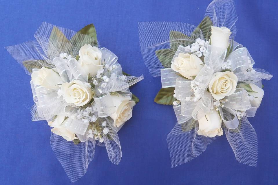 Corsages consisting of white spray roses.