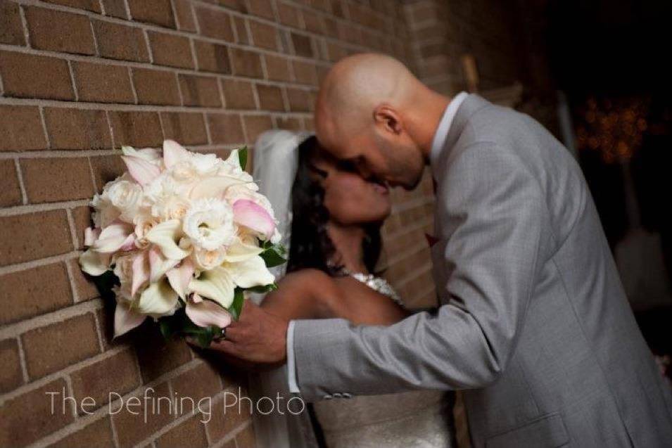 Newlyweds kissing with bouquet