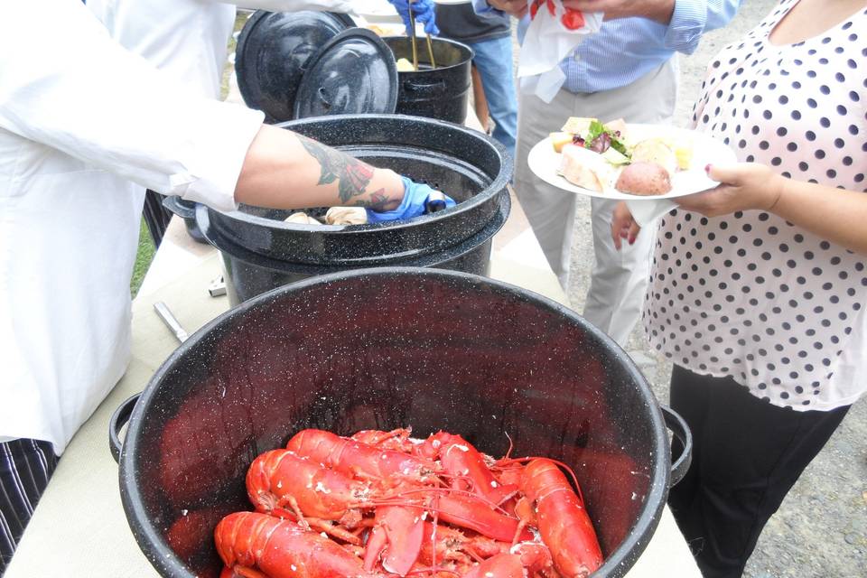 Casual lobster bake buffet set-up with an attentive server. Typical buffet set-up for a rehearsal dinner or casual affair.