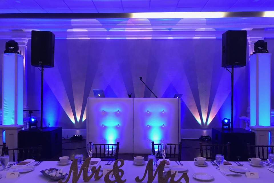 White dj facade with blue accent wall & gold tri-beams