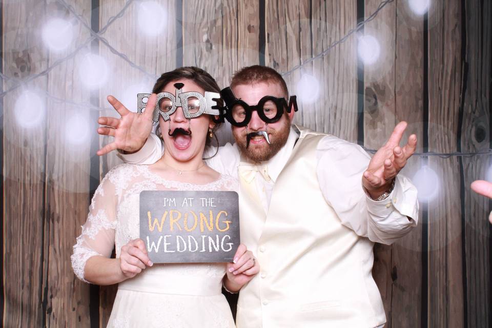 Bride & groom photo booth with rustic backdrop