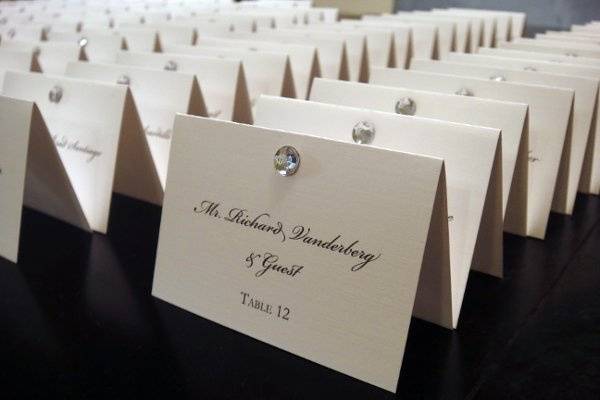 Escort cards printed on linen paper with rhinestone accent.