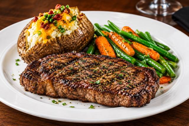 Sizzling Steak Dinner with Loaded Potato.png