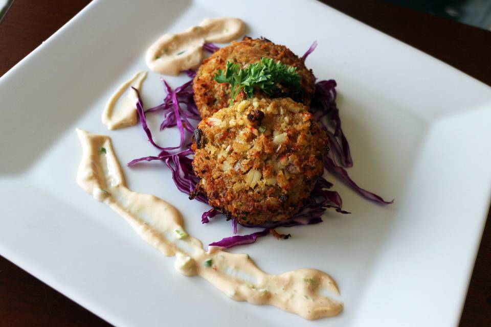 Crab cakes with a sweet red cabbage garnish.