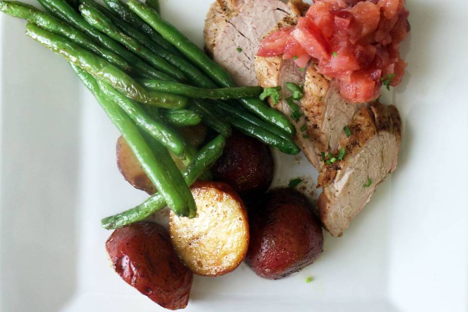 Sliced pork roast with homemade apple chutney, garlic and rosemary roasted potatoes, and crispy green beans.