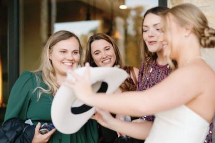 Bride shows guests her hat