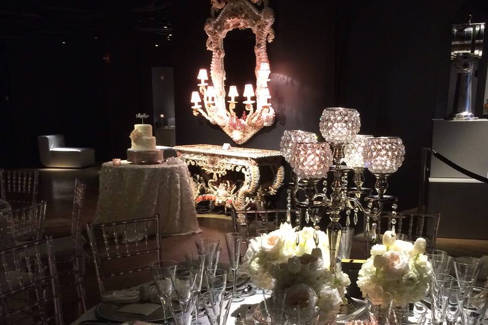 Table setting with the cake table in the background for a wedding at the Gallery of Amazing Things in Dania Beach, Florida.