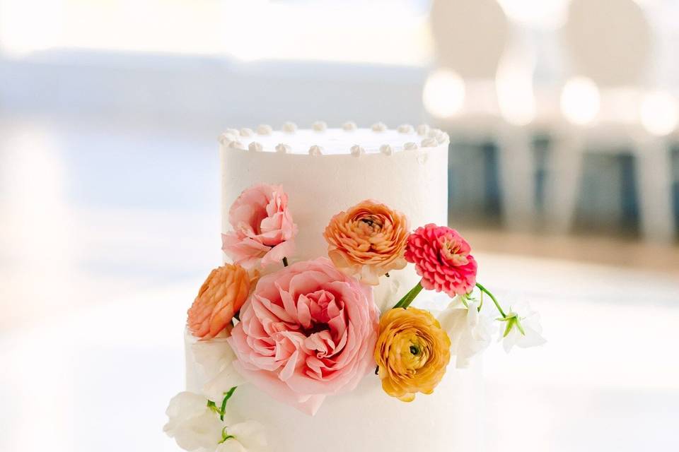 White two tier cake with fresh flowers