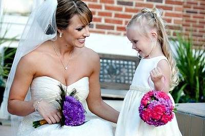 Andrea and her flower girl. The flower girl is carrying a pomander of hot pink and purple mini carnations with a custom made wire handle.