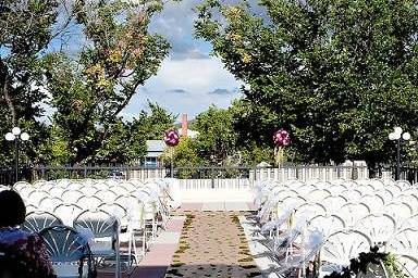 A view of the aisle. The aisle runner is custom made from kraft paper and ivy leaves with an ivy garland at the end. Looking up to the front are two large pomanders made with multi colored carnations to match the bridesmaid's bouquets and green hanging amaranthus.