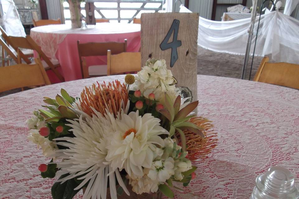 Centerpieces in birch covered cubes with pincushion protea, fuji mums, stock, hypericum berry