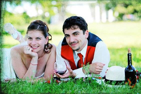 A couple having picnic in a field. This is a Gypsy themed wedding.