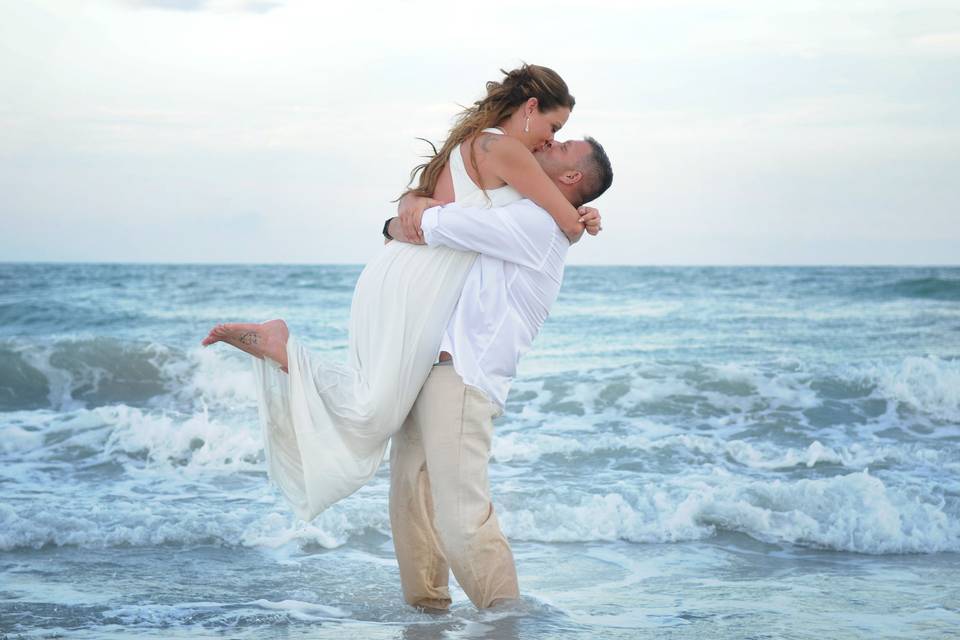 Newlyweds kiss on the shore