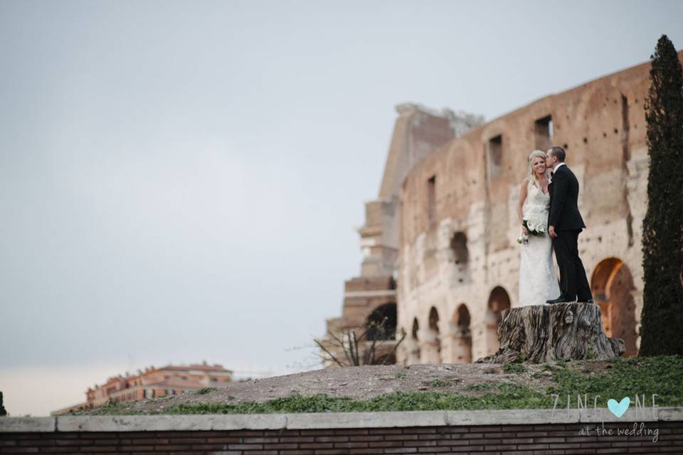 Bride and groom in front the Coliseum in the very centre of Rome (unconventional perspective)