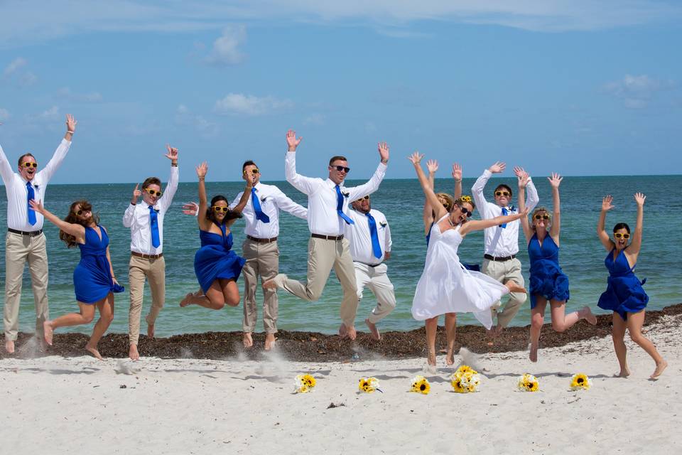 Wedding party jumping on the beach