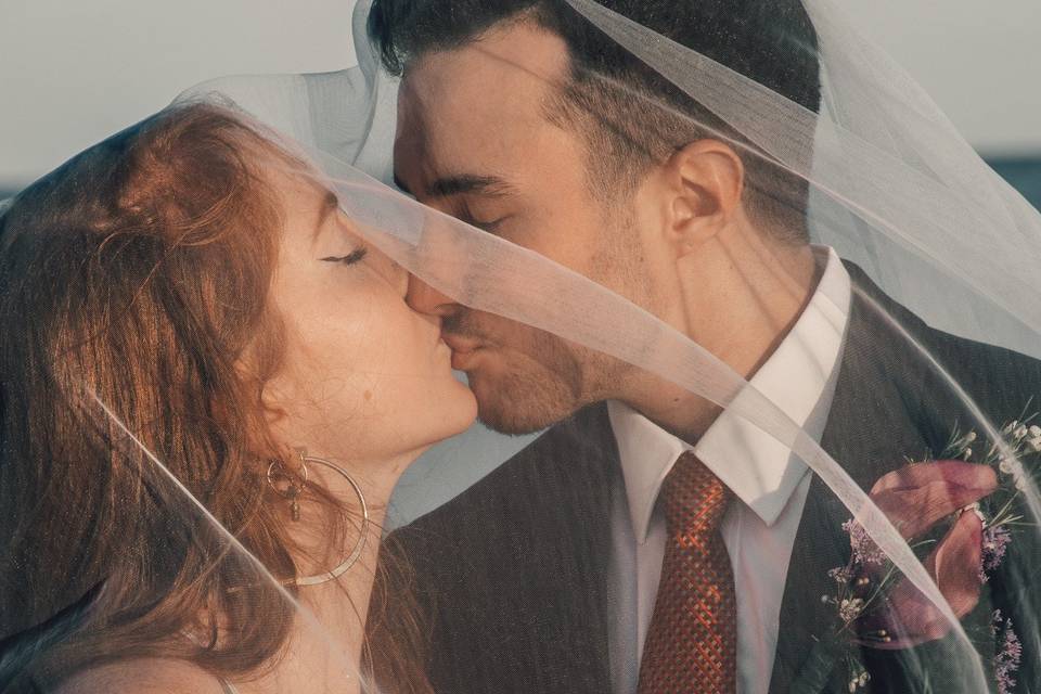 Couple kissing under veil