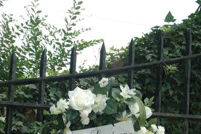 Iron gates to magnolia hill are personalized with white rose wreaths.