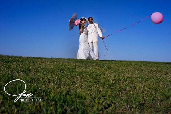 Newlyweds with a balloon and umbrella