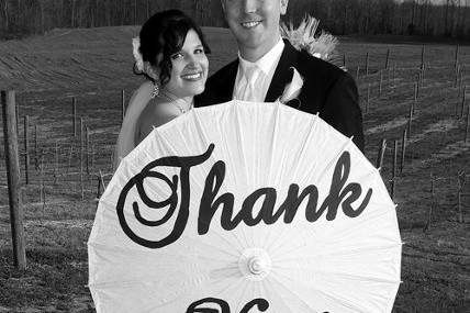 Bride and groom holding a thank you sign