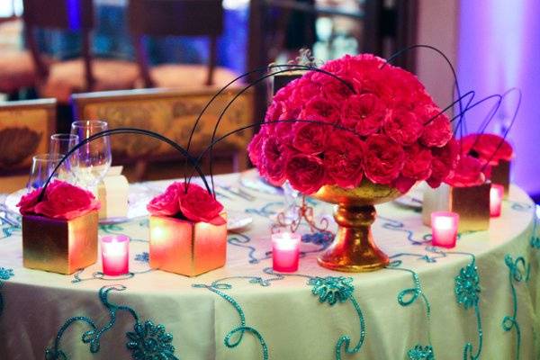 More open magnificent garden roses with blue accents and elegant gold containers