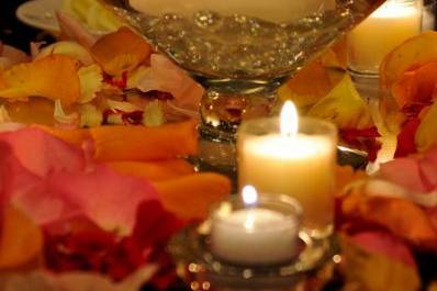 Simple centerpieces of floating candles, rose petals & more candles set the room aglow with warmth & romance