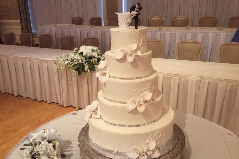 All white wedding cake with figurine on top