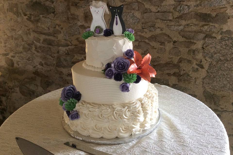 White wedding cake with cool tone flowers