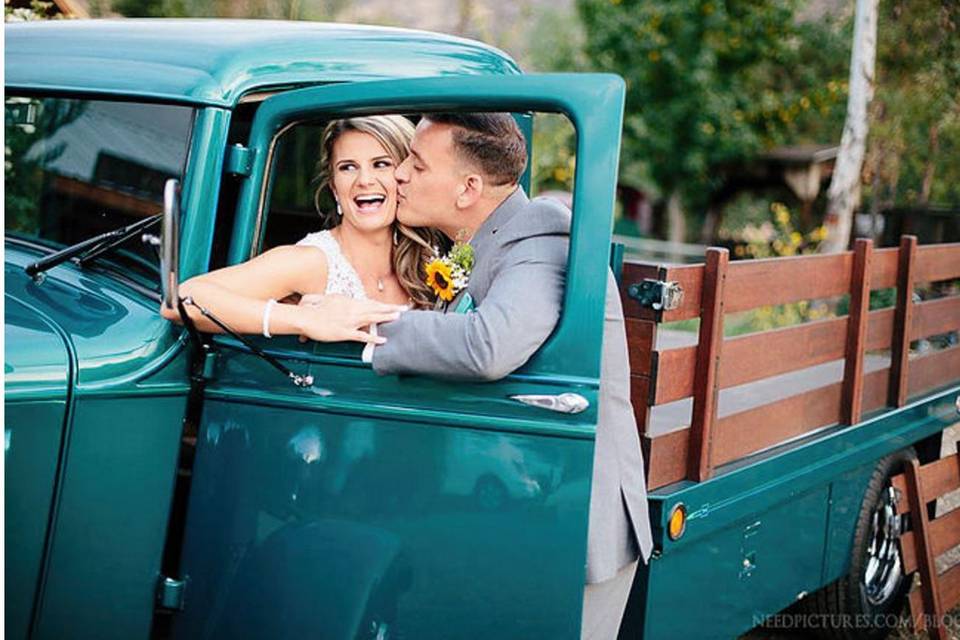 Groom kisses his bride at the truck