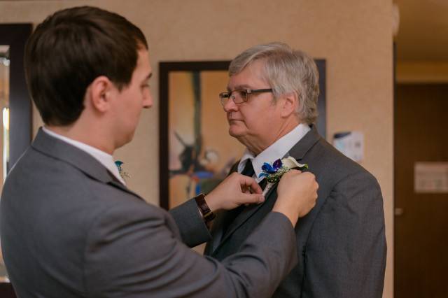 Groom putting on his father's boutonniere