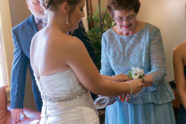 Bride putting on her mother's corsage