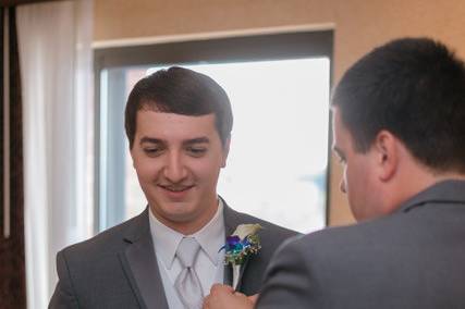 Putting on the groom's boutonniere