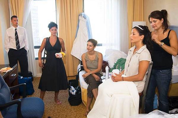 Brooklyn, New York. Jewish wedding. Tieing veil to bride's head in hotel room.