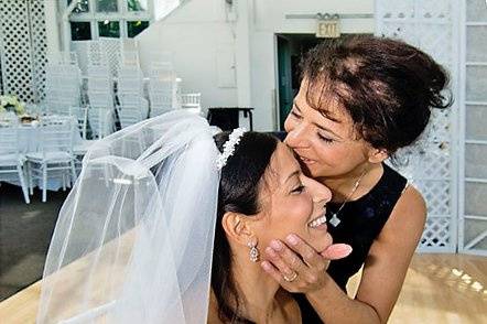 Brooklyn, New York. Jewish wedding. Mother kissing bride in recetion area.
