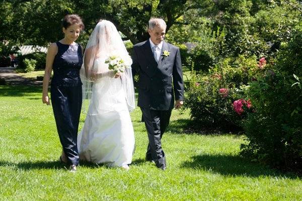 Brooklyn Botanical Ggarden, New York. Jewish wedding. Bride and parents walking to altar.