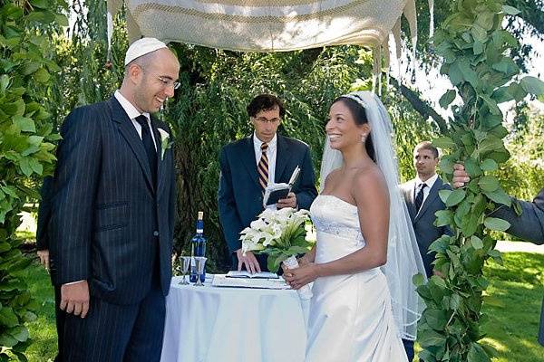 Brooklyn Botanical Ggarden, New York. Jewish wedding. Bride and groom at altar with rabbi.
