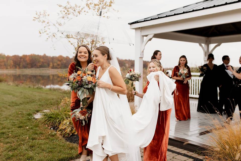 Bridesmaids help bride in rain