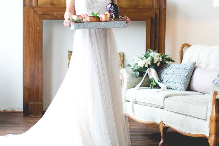 We loved the juxtaposition of soft hues and wood + metal touches for this Georgia wedding styled shoot! Pale pinks graced this inspiration in the form of fabrics – a sweet barely blush wedding gown from Fabulous Frocks of Atlanta, as well as throw pillows and covers for the lounge seating area (with a stunning DIY boxwood wall backdrop).