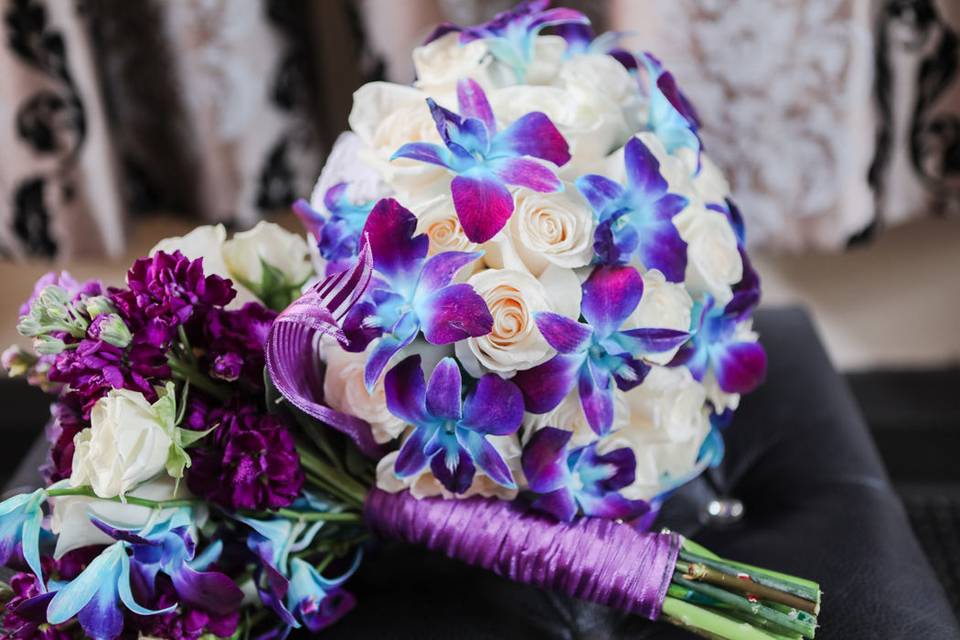 Shades of ivory, purple and blue bouquets. Orchids, roses, stock.