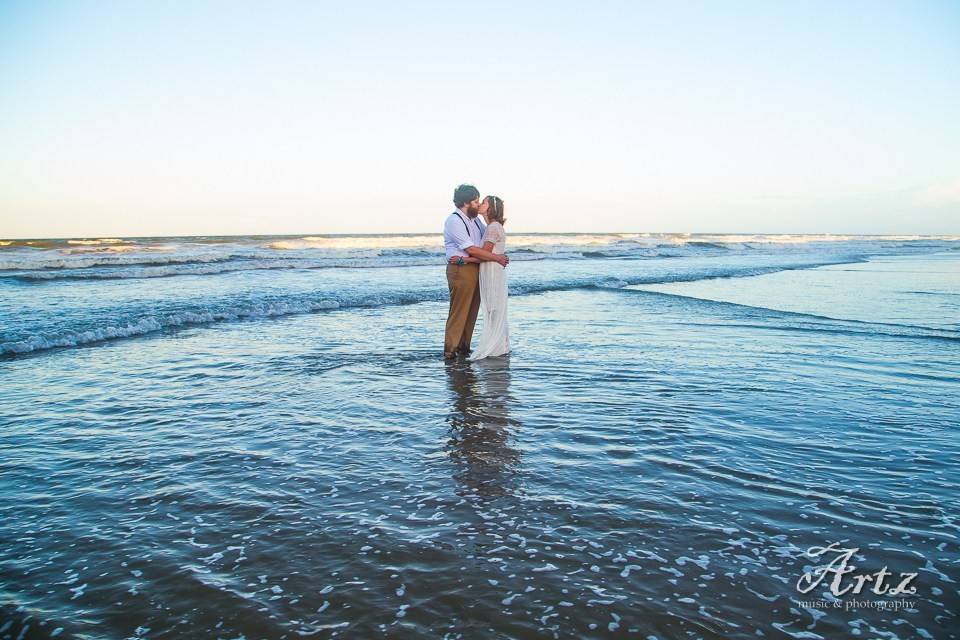 Couple kiss along the shore