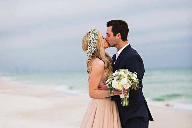 Newlyweds kiss by the beach