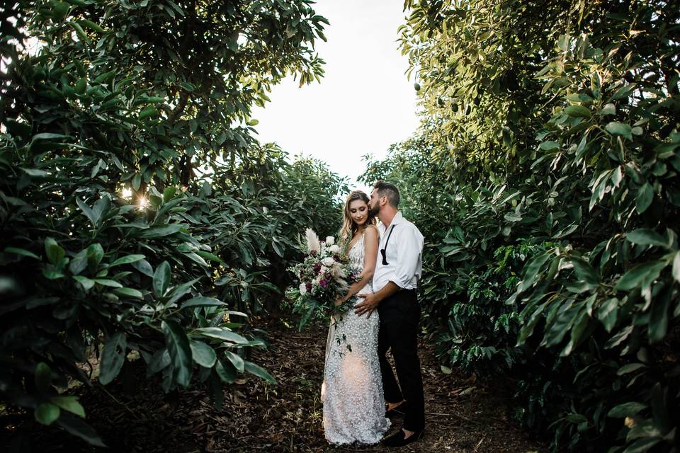 Bride/groom in orchard.