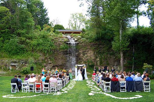 Wedding Ceremony at The Villa Waterfall at Springwoodwith a scroll of rose petals marking the aisle