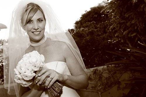 Blond bride with white bouquet & pearls.