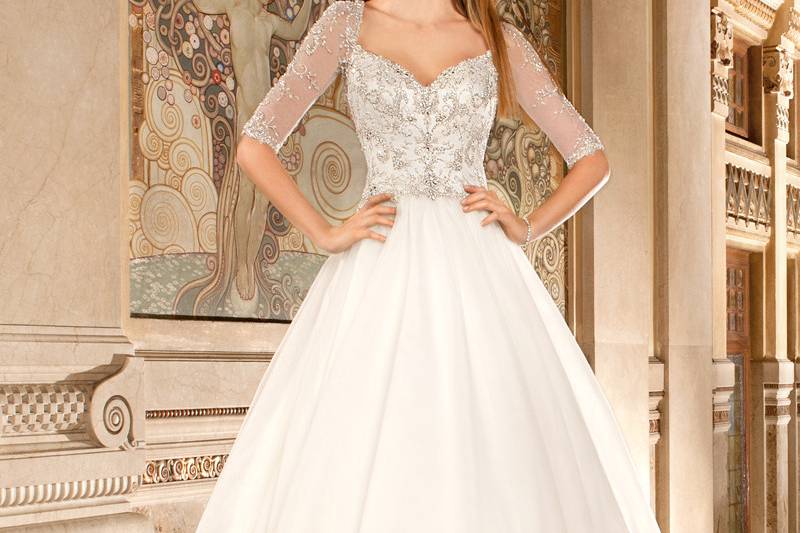 564This strapless, beaded tulle a-line gown features a heavily beaded embroidered bodice with soft Sweetheart neckline and a sheer v insert. The back is finished with a corset lace-up and chapel train.